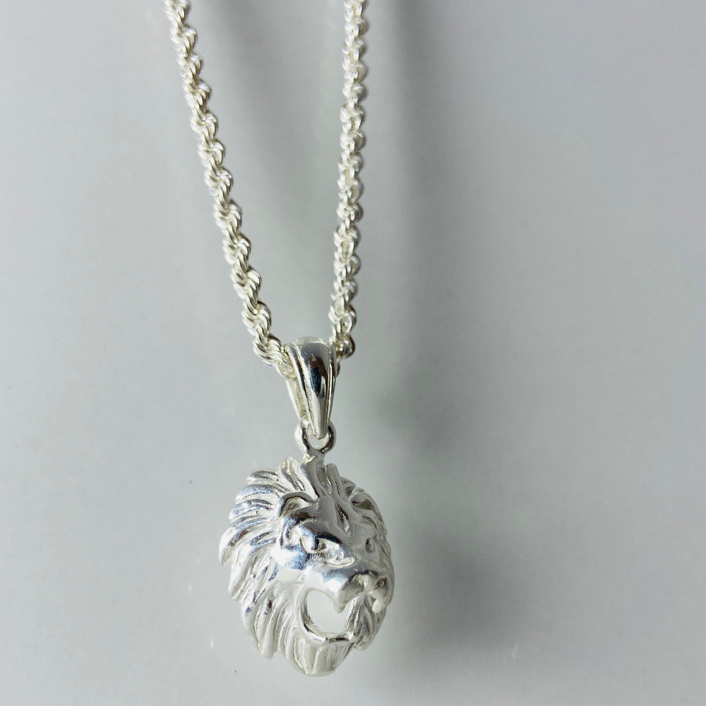 Silver lion head pendant on a chain against a light gray background Silver lion head pendant on a chain against a marble background Silver Lions head pendant necklace marble surface pendant necklace curb chain exclusive craftsmanship affordable luxury premium jewellery jewelry ladies women queens kings mens gents Deep Shine Jewellers DSJ Your Time To Shine best seller trending 925 silver sterling silver cape town artisans christmas gifts present festive season holiday gifts for love ones