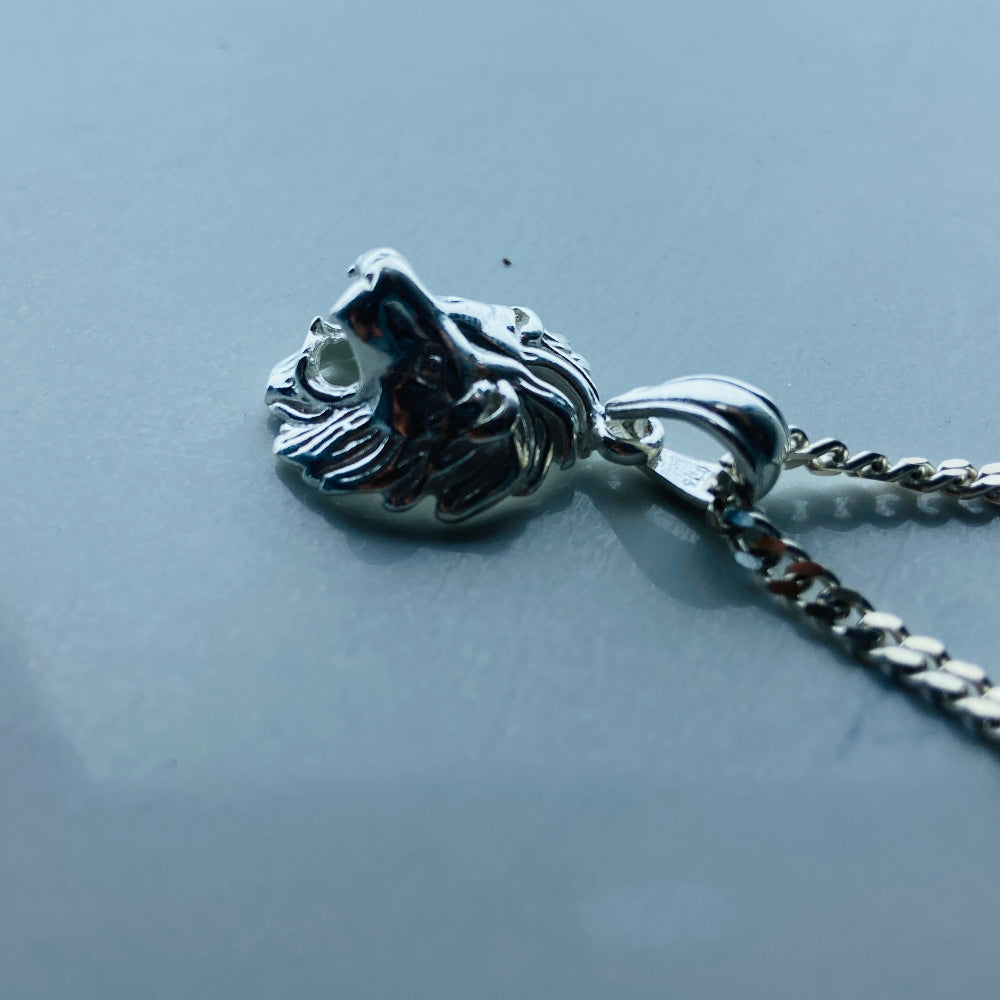 Silver lion head pendant on a chain against a light gray background Silver lion head pendant on a chain against a marble background Silver Lions head pendant necklace marble surface pendant necklace curb chain exclusive craftsmanship affordable luxury premium jewellery jewelry ladies women queens kings mens gents Deep Shine Jewellers DSJ Your Time To Shine best seller trending 925 silver sterling silver cape town artisans christmas gifts present festive season holiday gifts for love ones