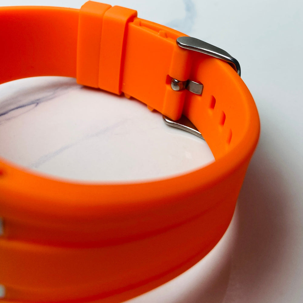 Orange watch strap on a marble surface Wristwatch with orange strap and red face on a white background silver watch with black and orange face on a white marble surface MX mens watch stainless steel watches timepiece timeless luxury best seller trending Deep Shine Jewellers DSJ Your Time To Shine quartz movement black dial gold stick markers 36mm gold bezel rubber strap orange christmas sale xmas present holiday season festive season 