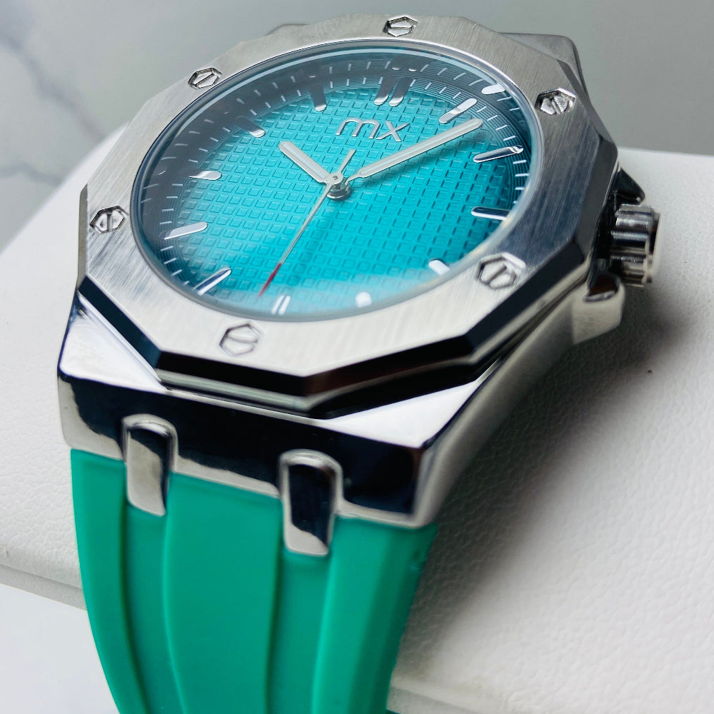 Turquoise watch with a silver case on a light gray surface Wristwatch with orange strap and red face on a white background silver watch with black and orange face on a white marble surface MX mens watch stainless steel watches timepiece timeless luxury best seller trending Deep Shine Jewellers DSJ Your Time To Shine quartz movement black dial gold stick markers 36mm gold bezel rubber strap orange christmas sale xmas present holiday season festive season 