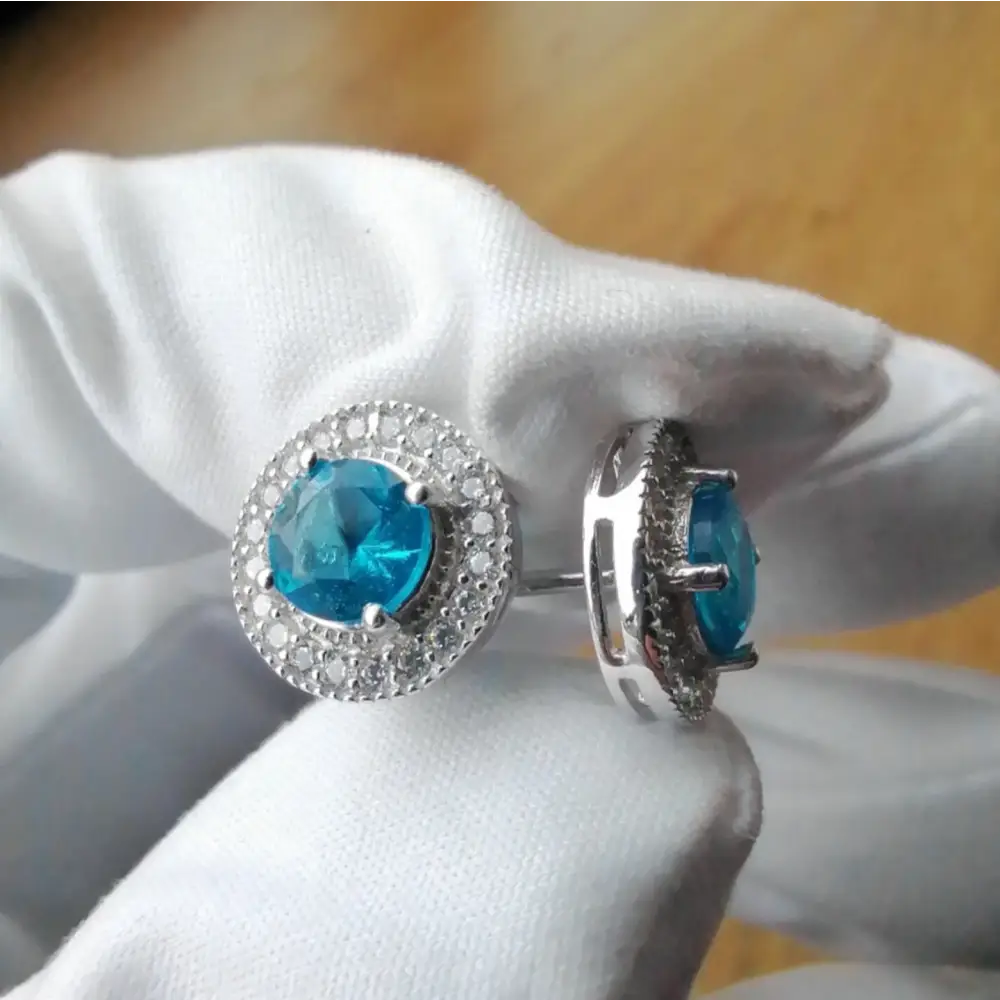 White gold silver Aqua Radiance earrings with blue gemstone and cubic zirconia halo