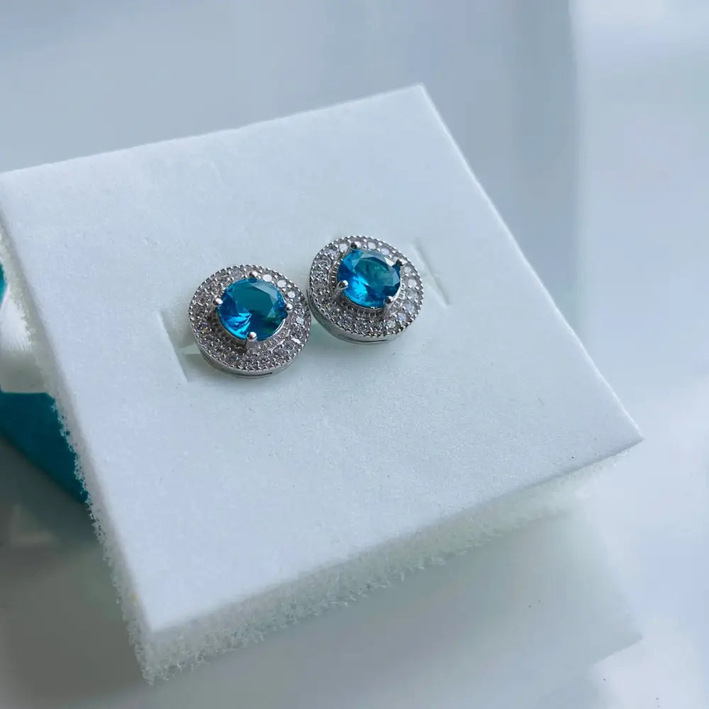 Pair of teal gemstone stud earrings with white gold silver halo and small white stones