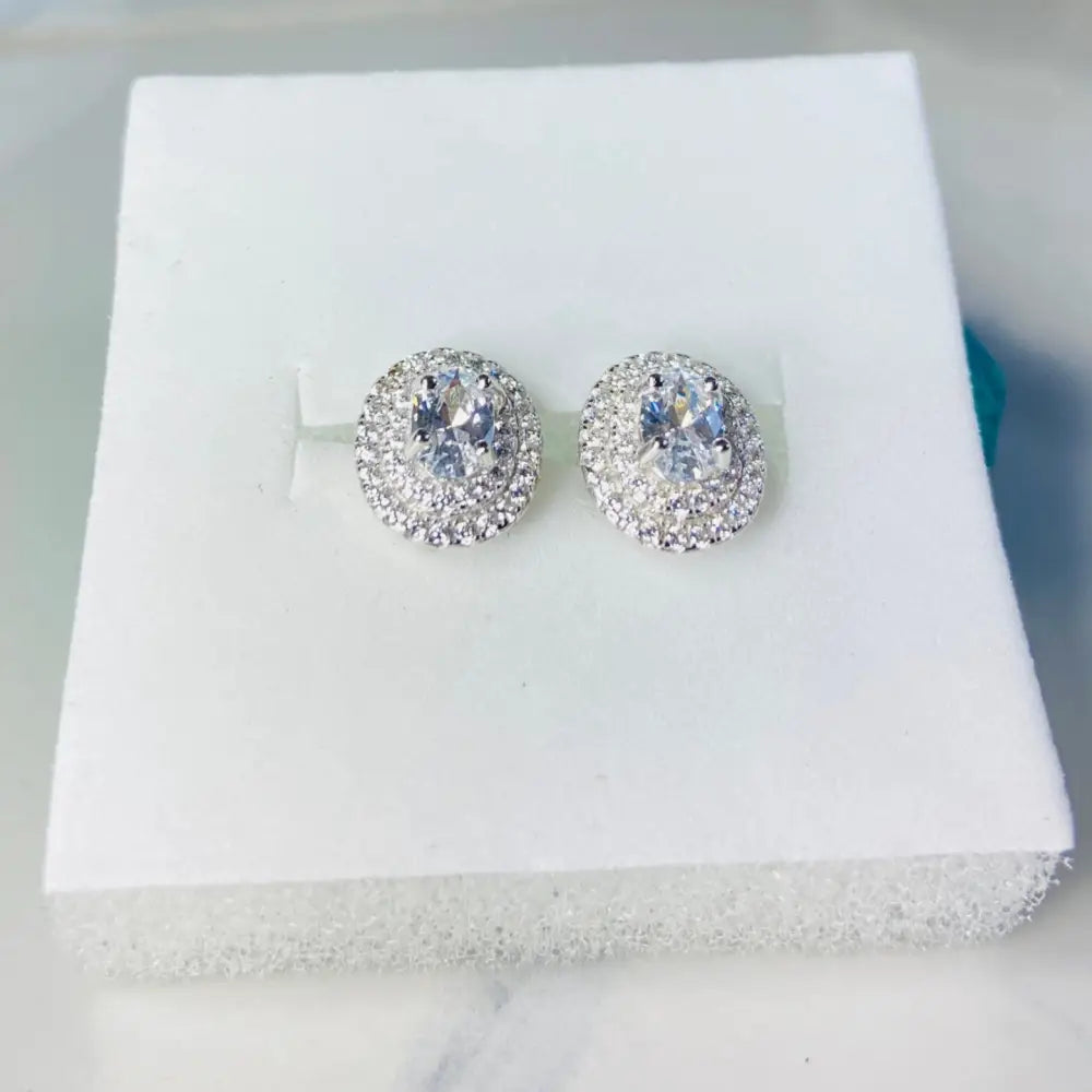 White gold silver flooded oval halo stud earrings with large central clear stone