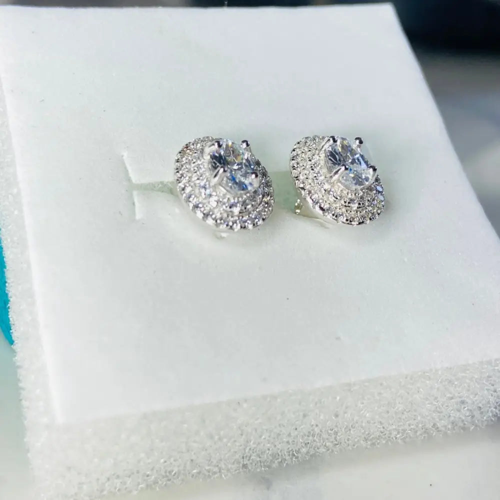 Dazzling oval halo stud earrings in white gold silver with silver flooded design and clear stones