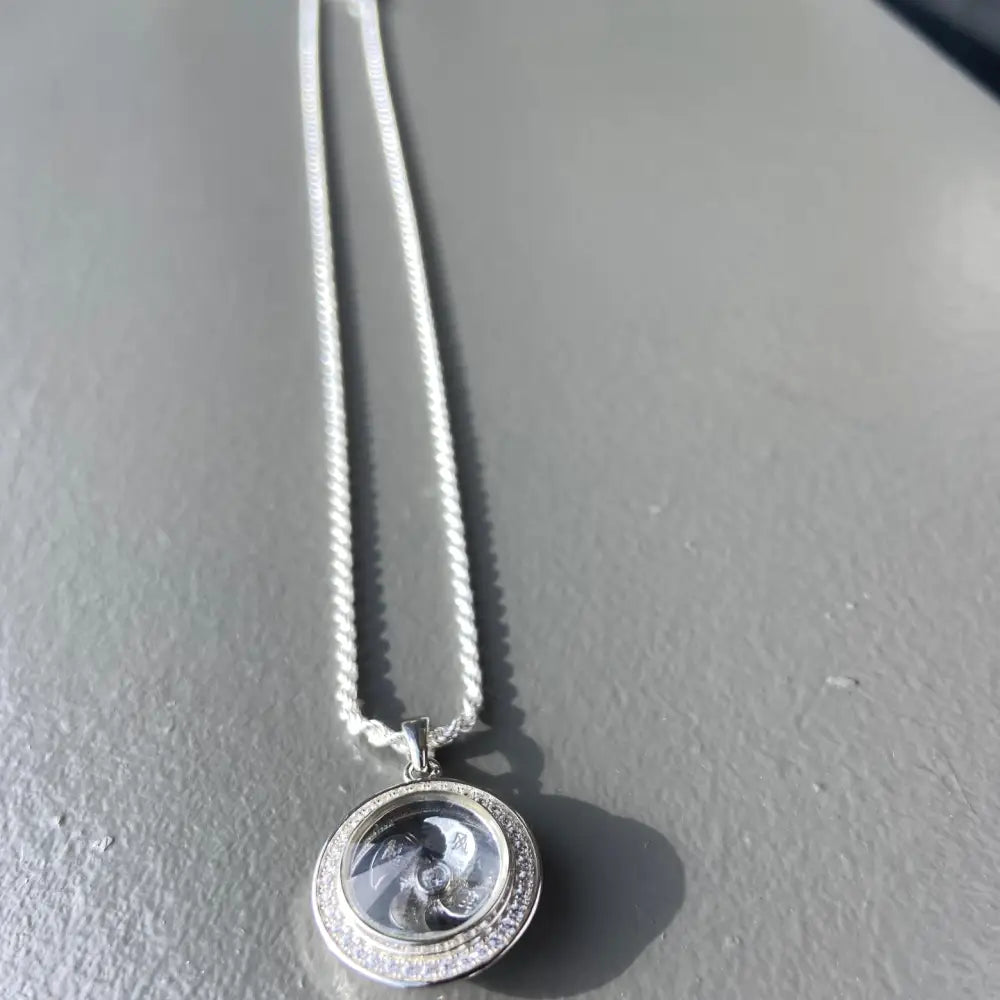 Silver flooded spinning necklace with circular locket and sparkling stones for elegant style