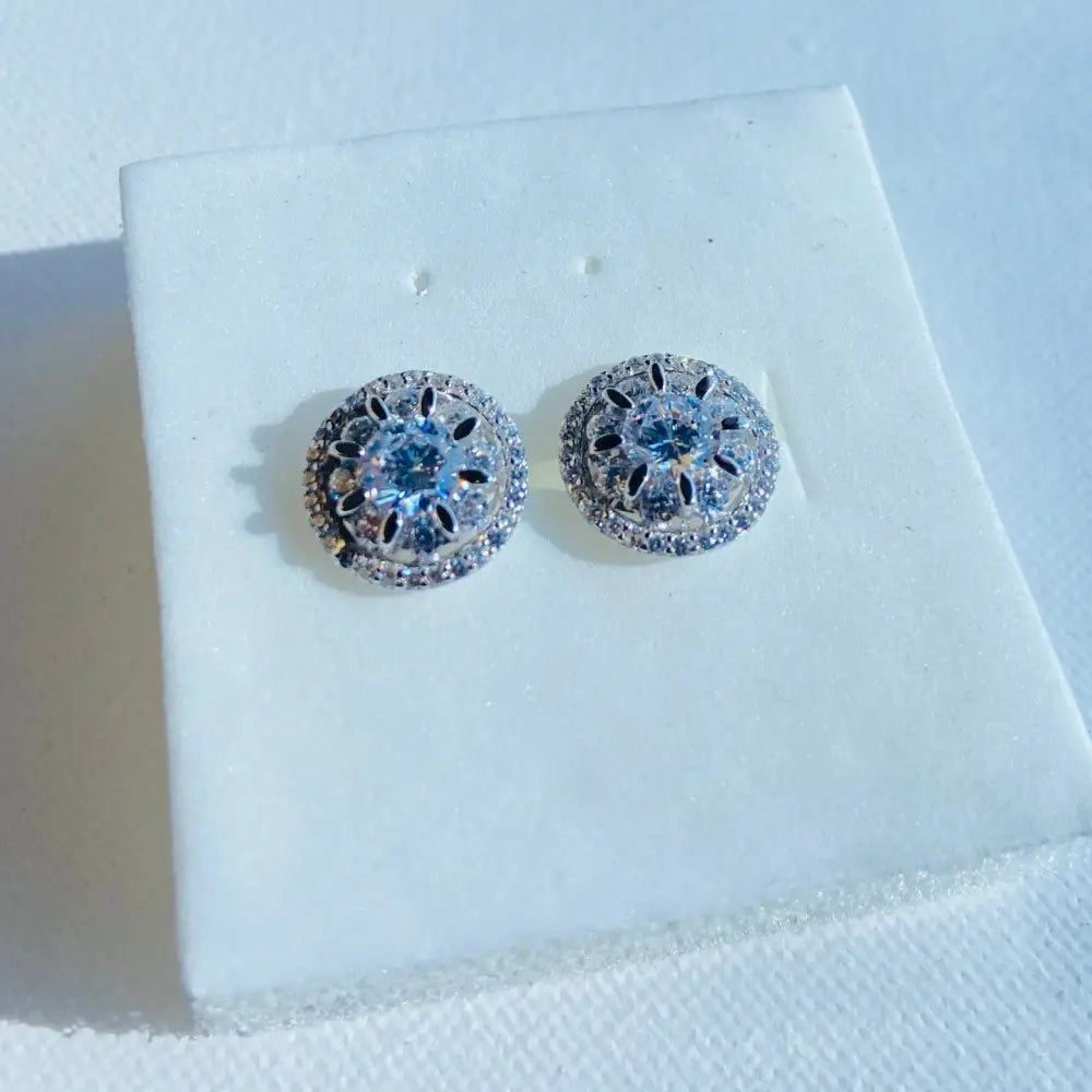 Silver ice wheel earrings with light blue gemstone and intricate filigree design