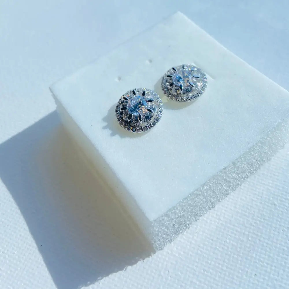 Silver ice wheel earrings with blue gemstone and clear accents in white gold silver finish