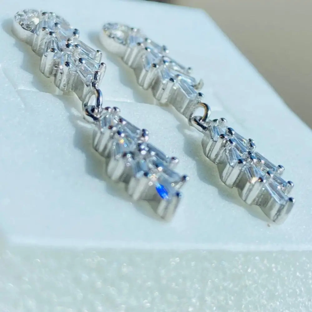 Sparkling white gold silver tapered earrings with baguette and round cubic zirconia stones