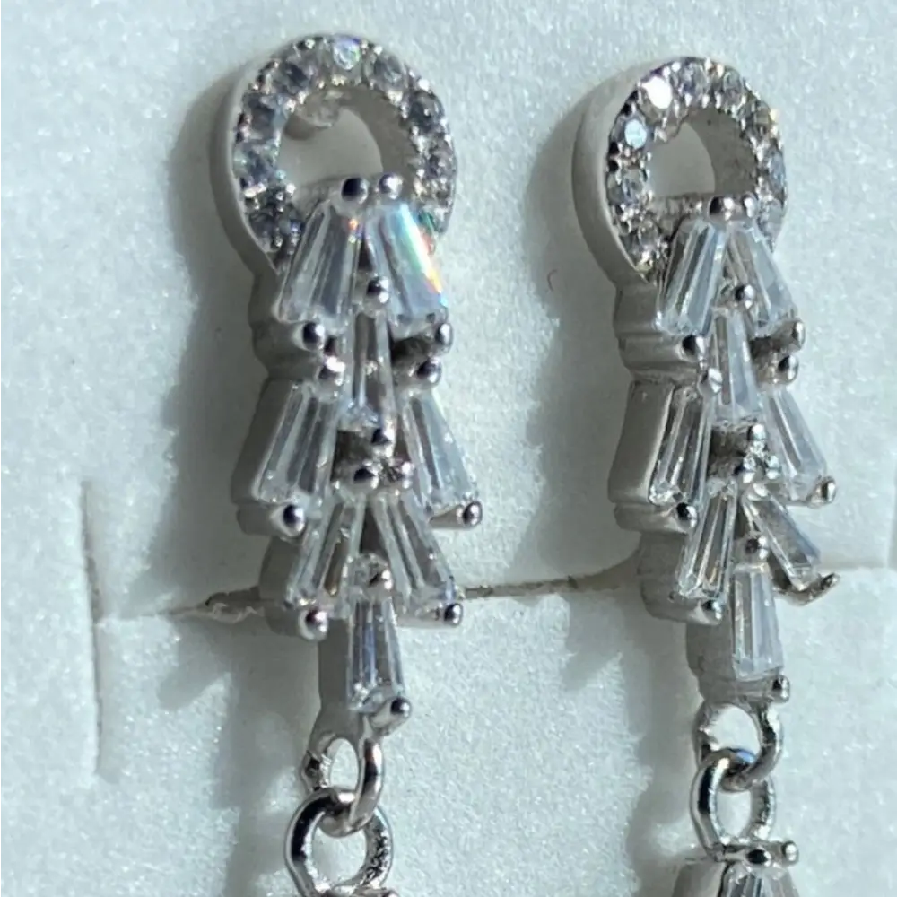 Silver-colored dangle earrings with round and baguette-cut cubic zirconia stones in white gold silver design