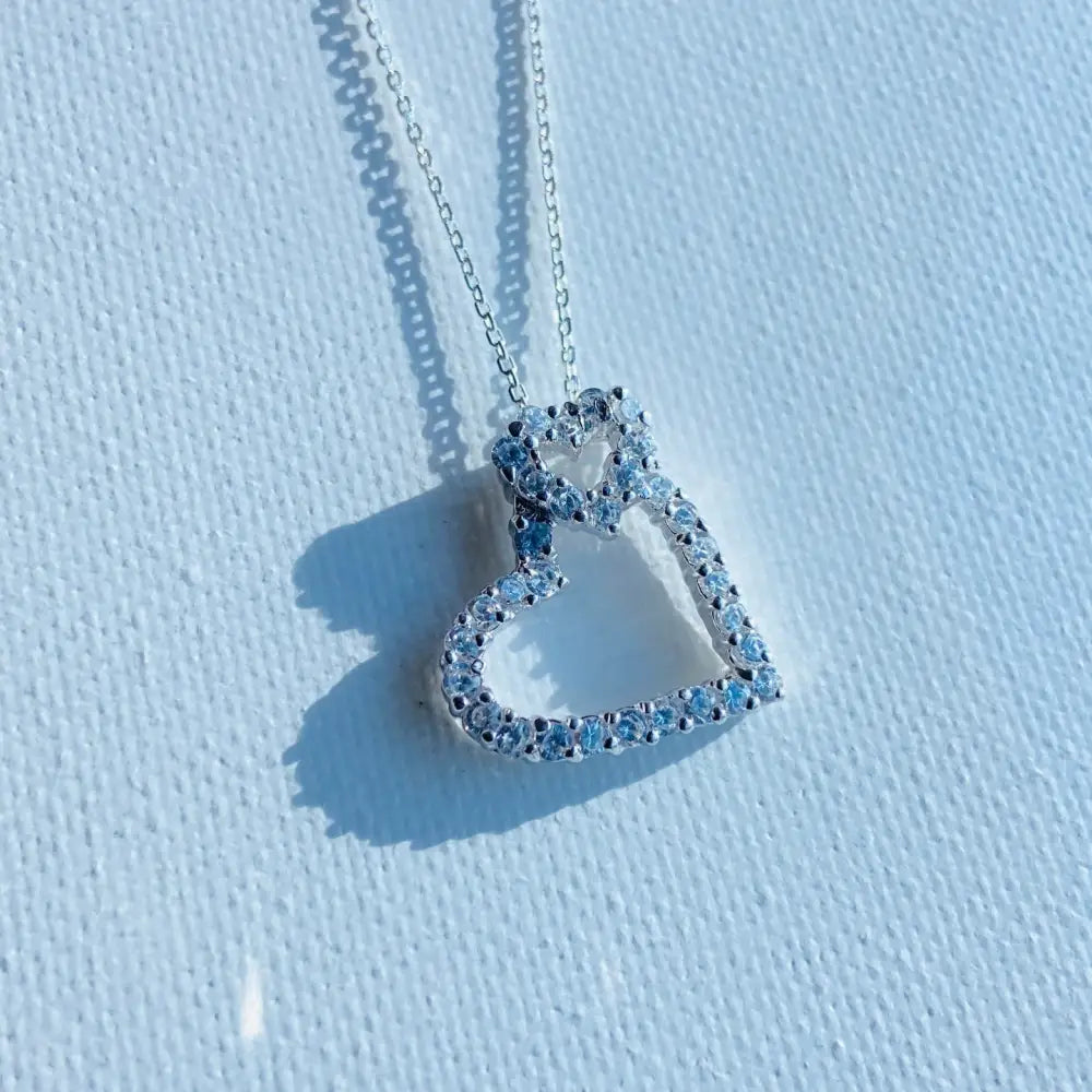 Silver heart-shaped pendant with sparkling gemstones from the Double Ice Heart Necklace in white gold