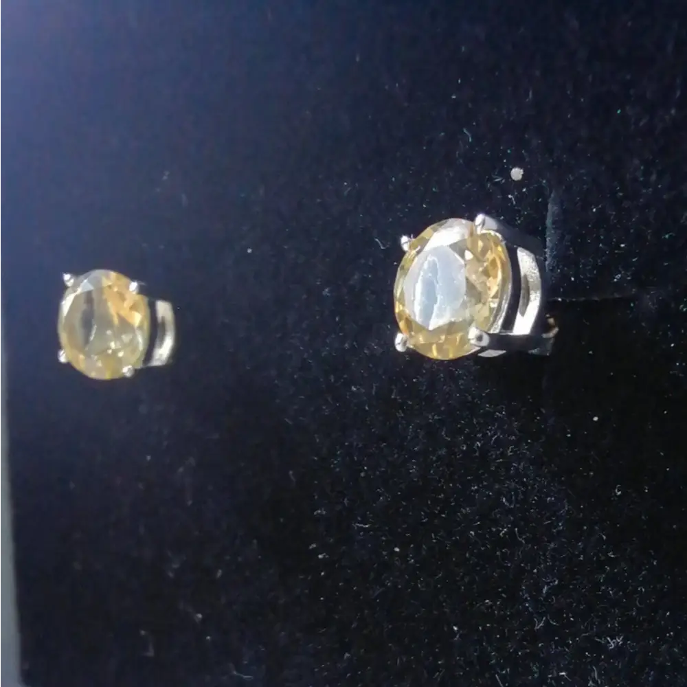 Silver-toned stud earrings with oval-cut yellow gemstones in white gold silver claw setting