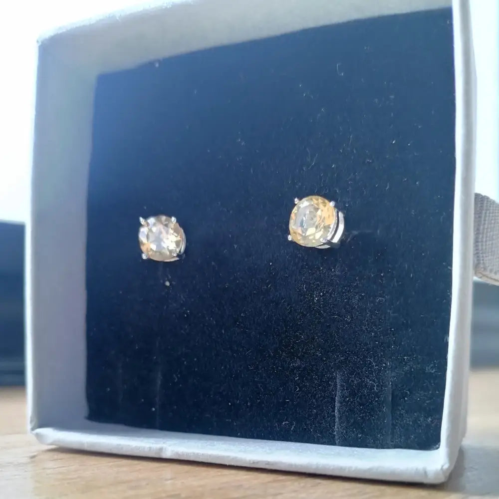 White gold silver claw precious citrine earrings featuring round-cut light yellow gemstones