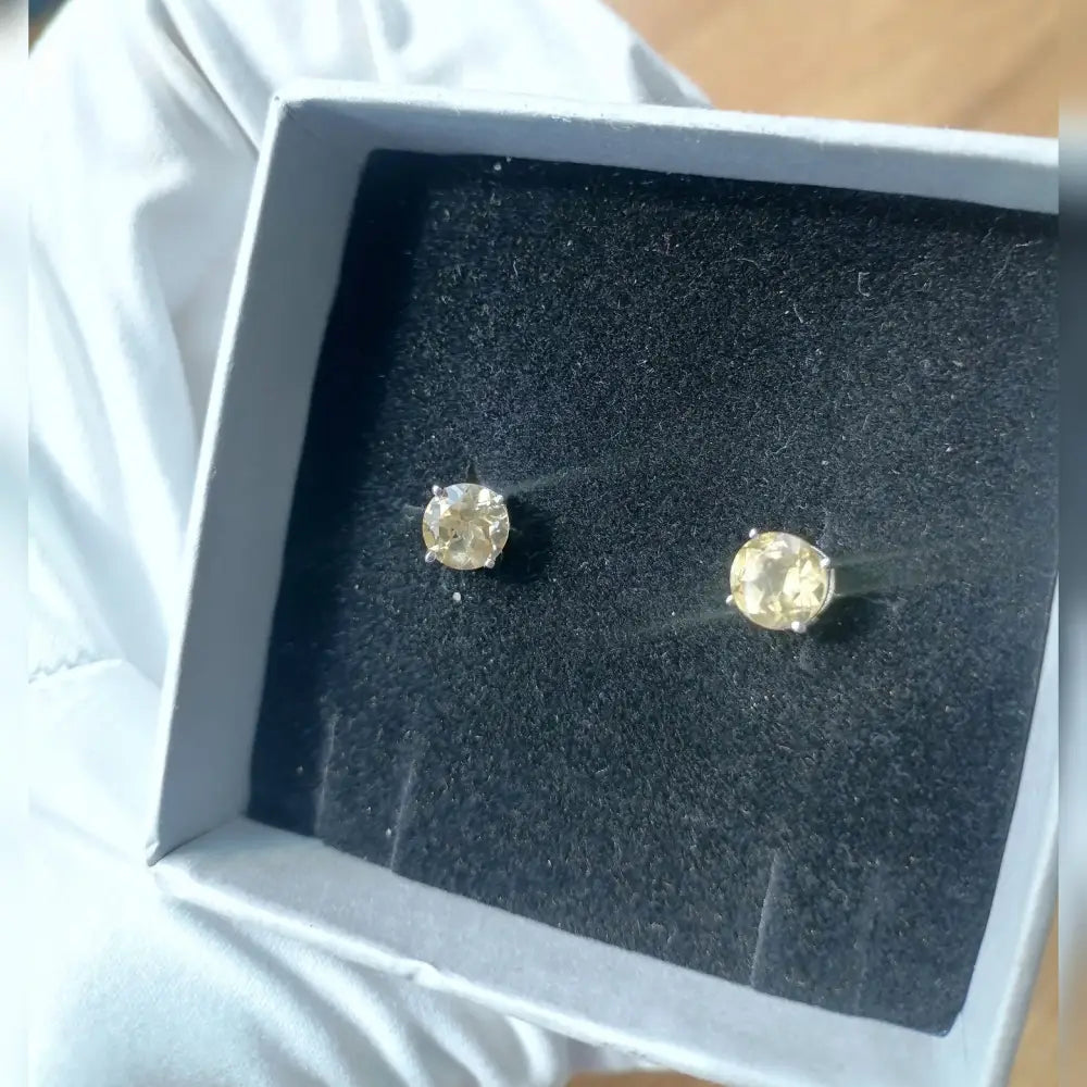 White gold silver claw precious citrine stud earrings in a white box with black interior