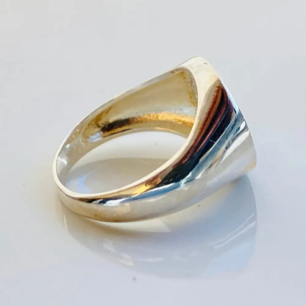 Gold-colored Fabiani ring with red, white, and green emblem and clear gemstones