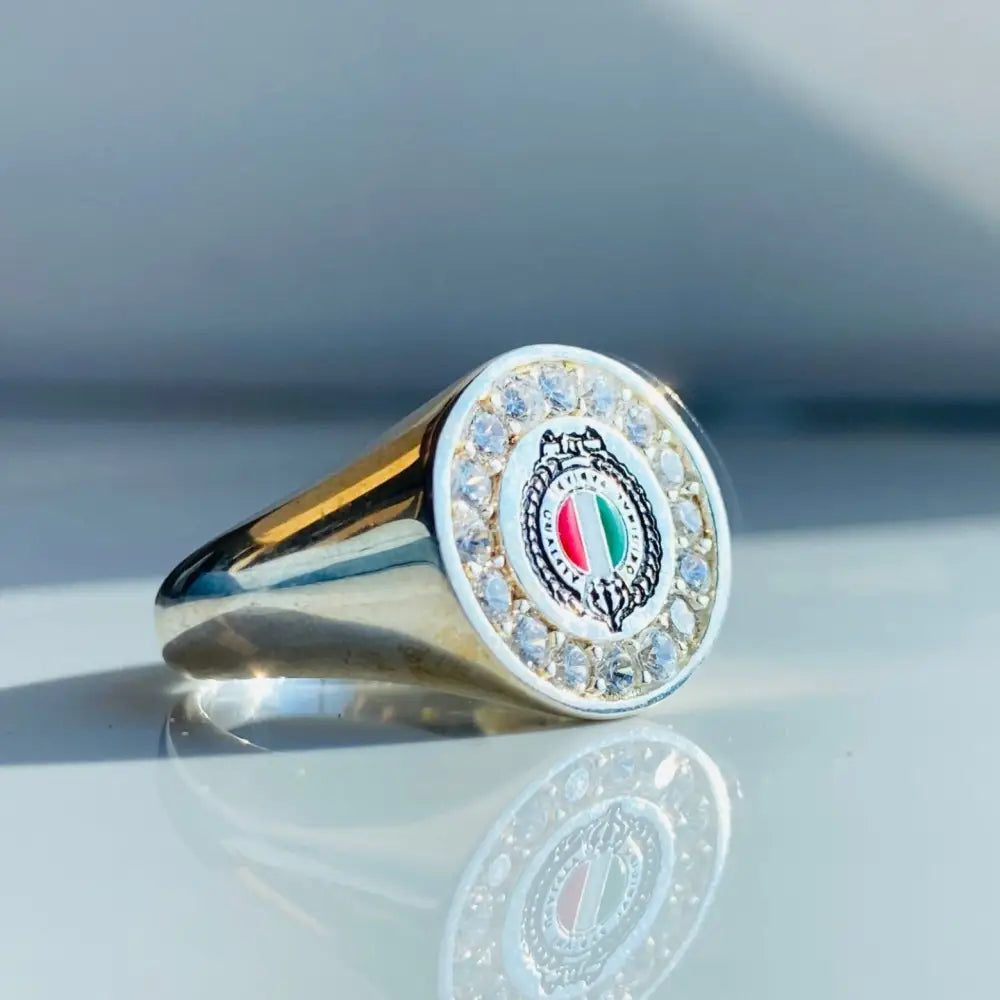 Gold-colored Fabiani ring with red, white, and green emblem and clear gemstones