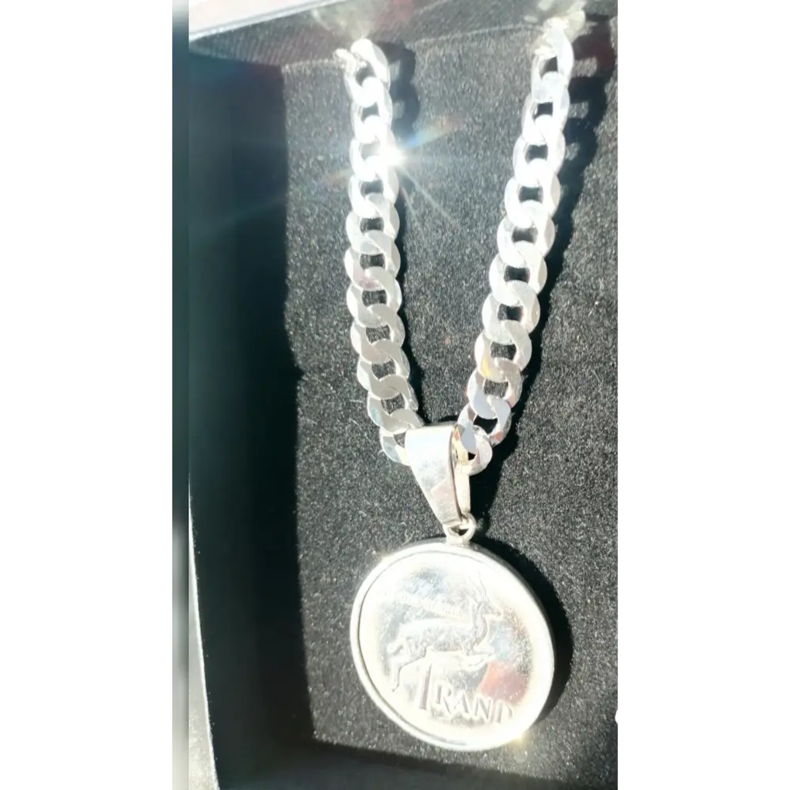 Silver flat curb necklace with springbok coin pendant featuring RAND text for statement jewelry. jewellery silver jewellery. Deep Shine Jewellers