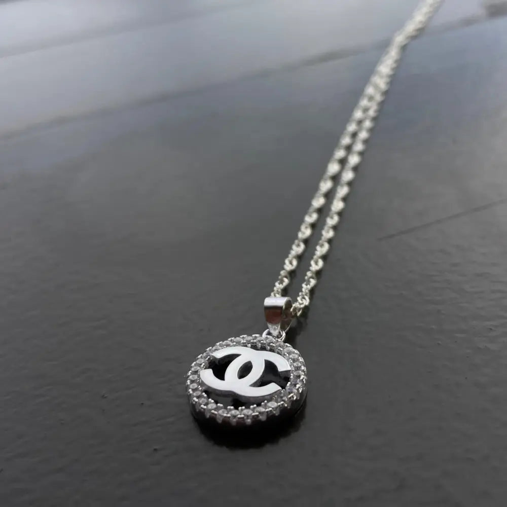 Silver Chanel necklace with double C pendant and halo of clear stones for timeless shine
