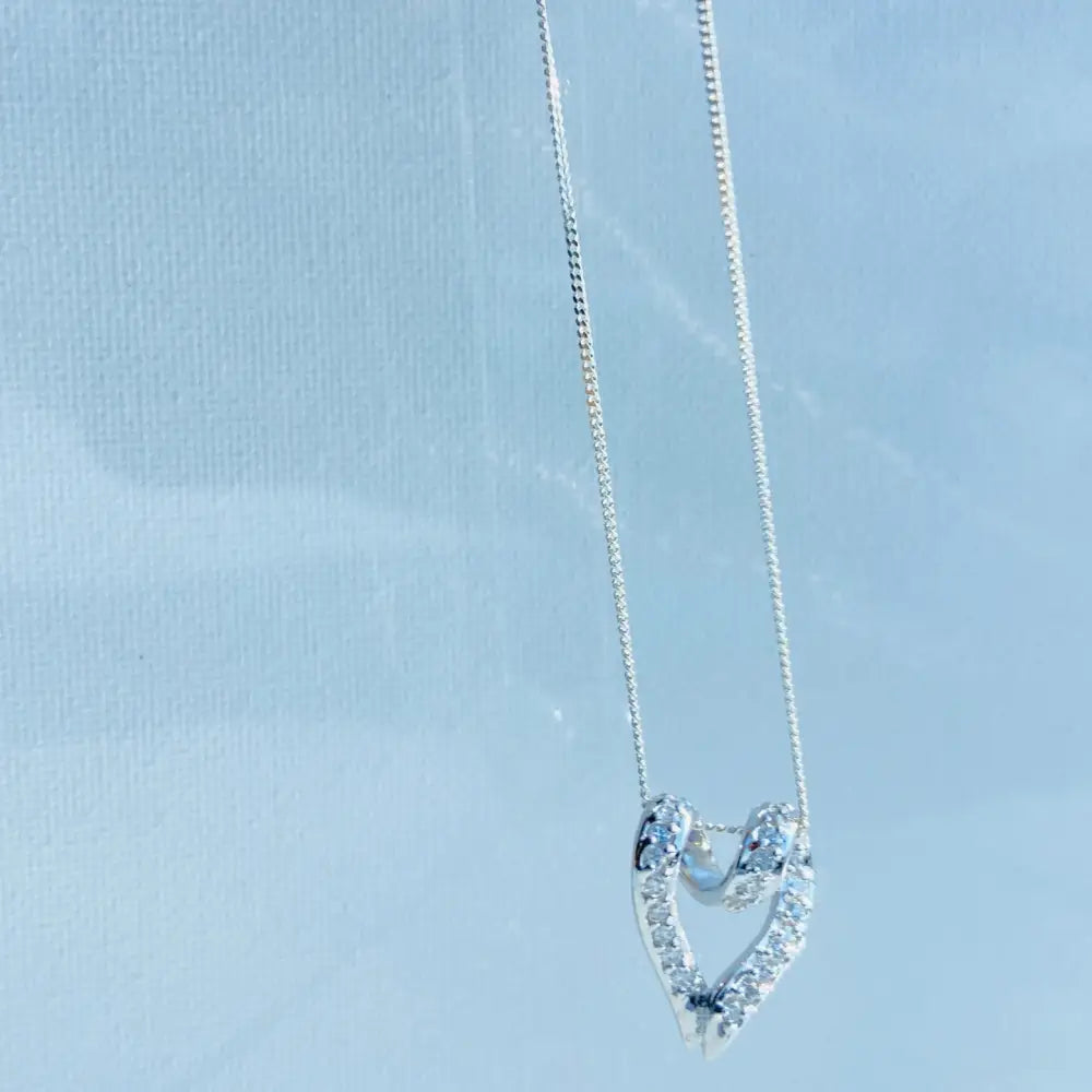 Silver looped heart pendant with pavé diamonds on delicate chain, perfect for elegant jewelry