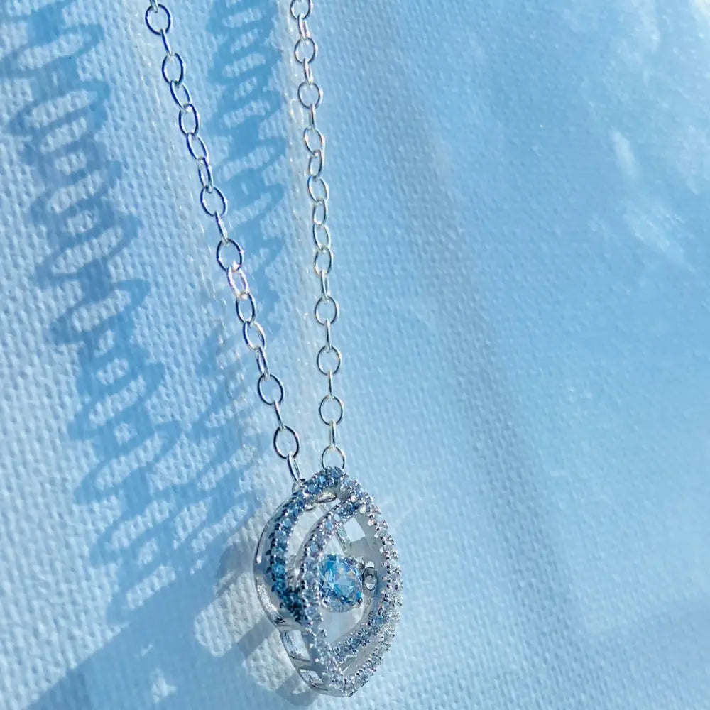 Silver chain necklace with oval-shaped eye pendant featuring clear stones and a sparkling gem. Jewellery silver jewellery Deep Shine Jewellers