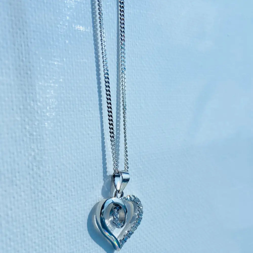 Silver heart-shaped pendant with central jewel and pavé diamonds on white gold curb chain. jewellery silver jewellery. Deep Shine Jewellers
