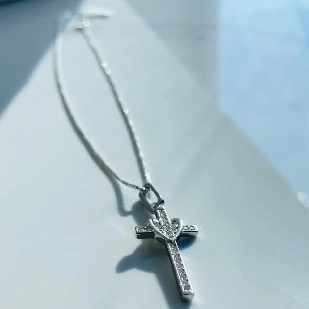 Silver-colored cross necklace with heart detail and gemstones, crafted in white gold silver for gold silver love. jewellery silver jewellery. Deep Shine Jewellers