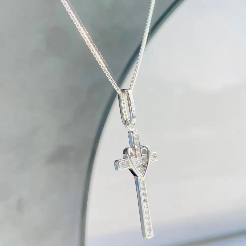 Silver-toned cross pendant with heart center and cubic zirconia accents on white gold silver chain. jewellery silver jewellery. Deep Shine Jewellers