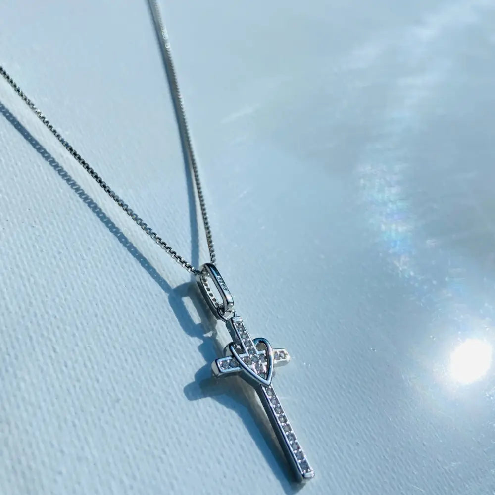 Sterling silver cross pendant with heart design and cubic zirconia stones in white gold silver finish. jewellery silver jewellery. Deep Shine Jewellers