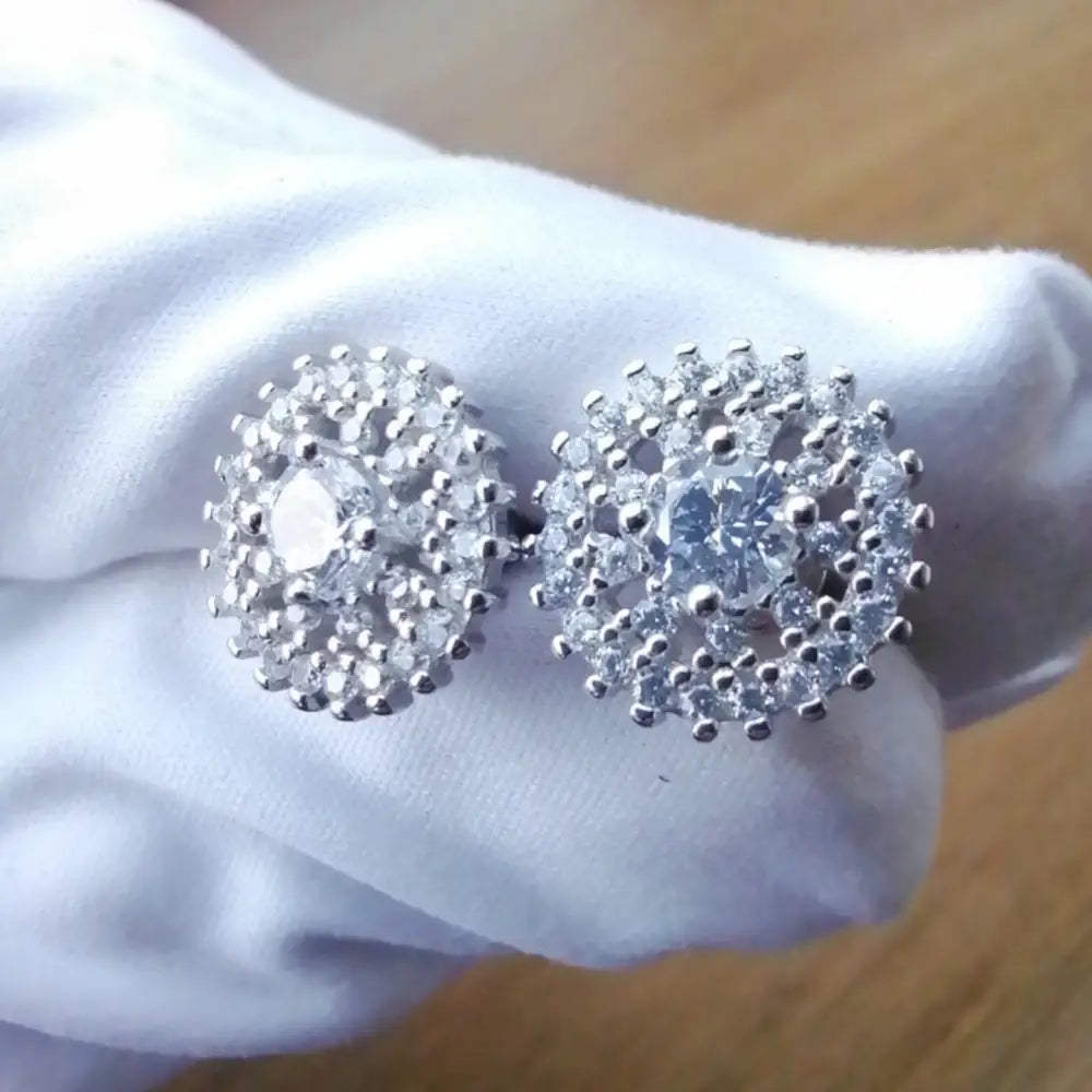 White gold silver stud earrings with central clear gemstone and surrounding smaller stones