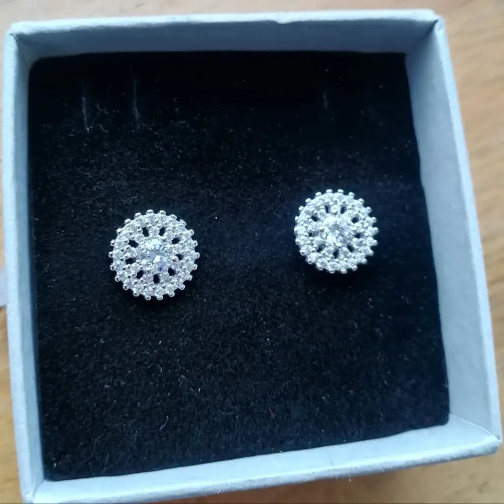 White gold silver stud earrings with clear gemstones in a snowflake floral design