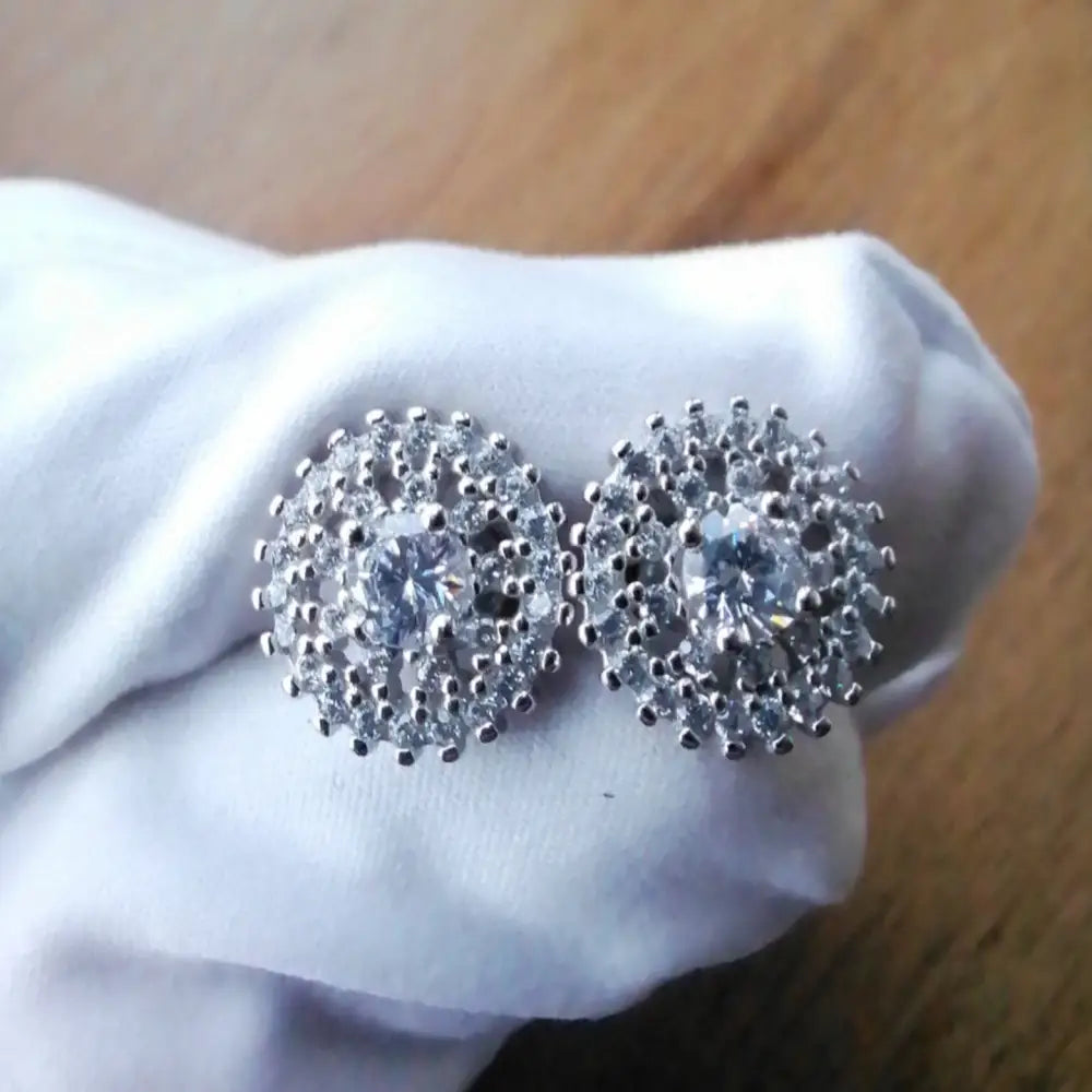 White gold silver stud earrings with central clear gemstone and surrounding smaller stones