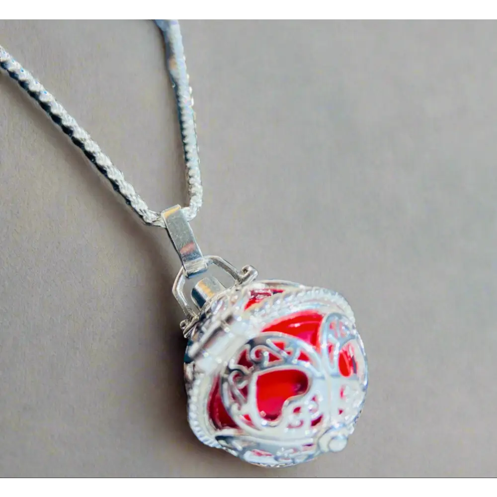 Silver locket casing featuring a vibrant red inner sphere on a twisted chain, Scarlet Heart Silver Locket Adornment. Jewellery silver jewellery. Deep Shine Jewellery