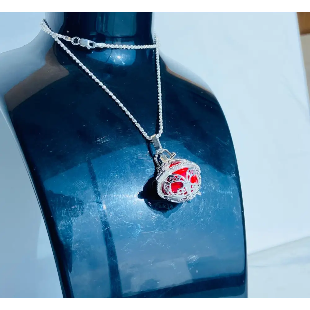 Silver locket casing featuring a red intricately caged spherical pendant on a silver chain. Jewellery silver jewellery. Deep Shine Jewellery