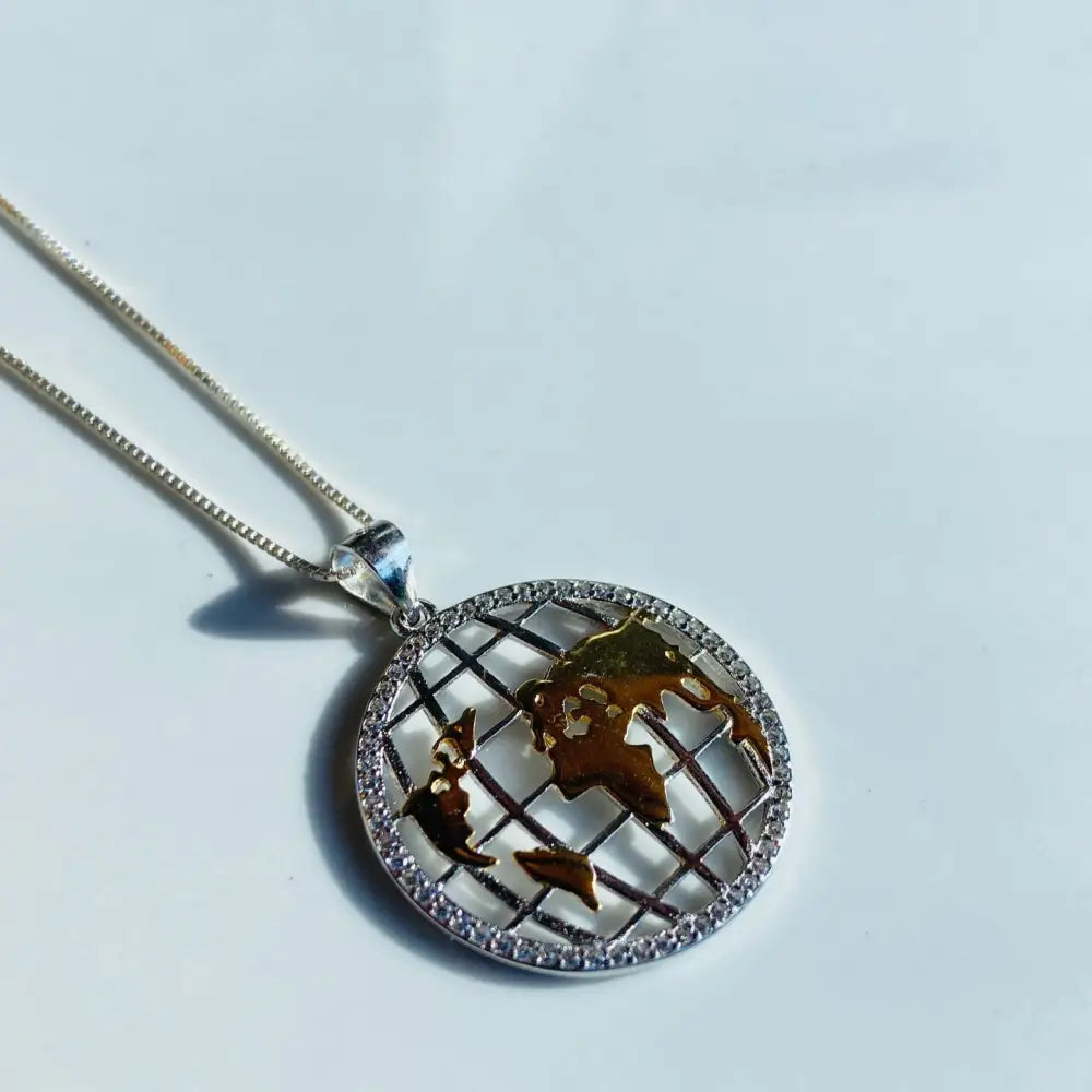 Silver world globe necklace with gold landmasses and diamond bezel for elegant jewelry. jewellery silver jewellery. Deep Shine Jewellers