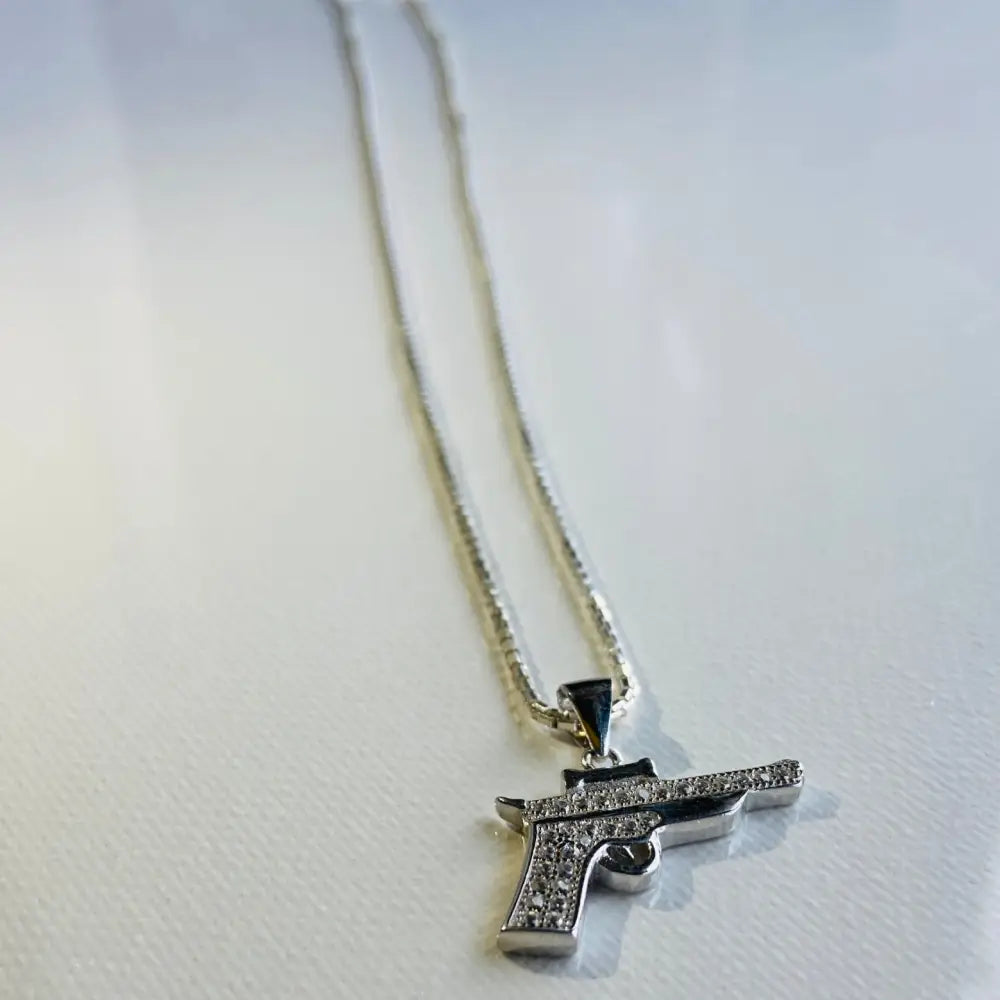Silver pistol pendant necklace with clear stones in white gold silver finish