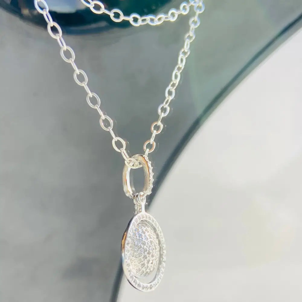 Silver chain necklace with white gold oval pendant encrusted with small clear stones. Jewellery silver jewellery Deep Shine Jewellers