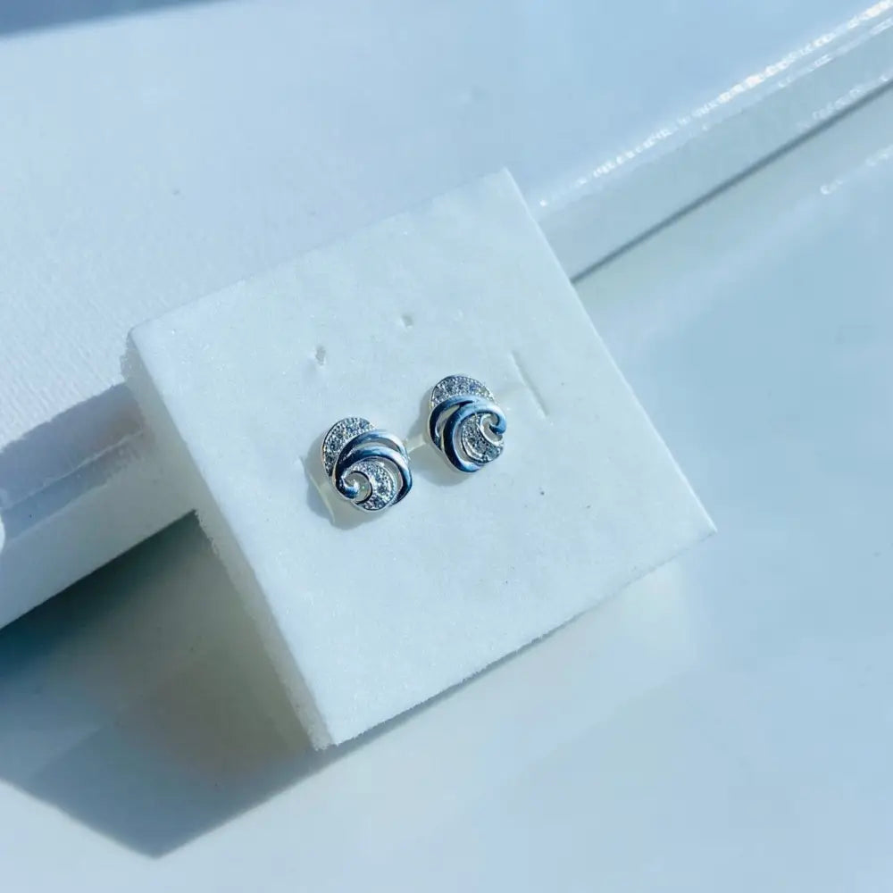 White gold silver swirling stud earrings with sparkling stones in the White Gold Ice Seashell collection