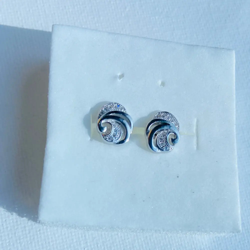 White gold silver stud earrings with swirling design and cubic zirconia accents