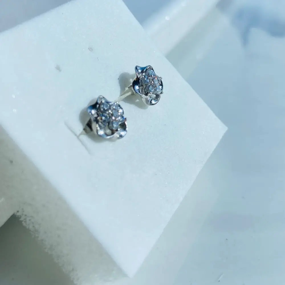 Matching pair of white gold silver ice pave flower stud earrings with small clear gemstones