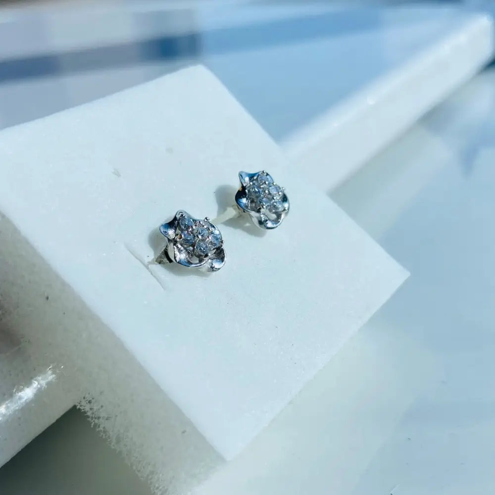 Silver-colored flower stud earrings with clear gemstones in white gold silver finish