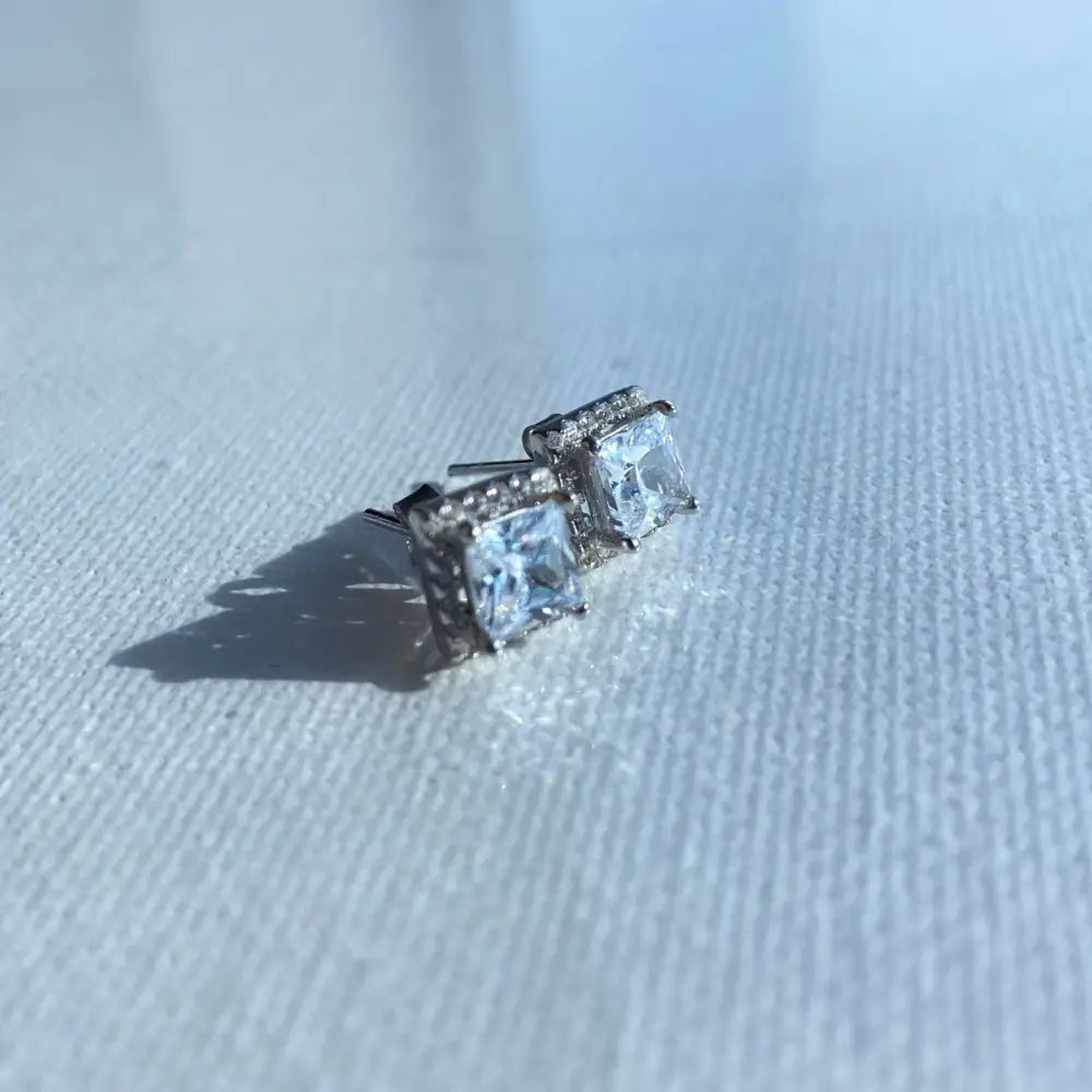 Silver-toned princess cut stud earrings in white gold silver with accent stones